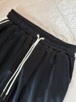 Pantaloni sportivi neri con corda bianca e fascia elastica, comodi e versatili per il fitness e il relax.