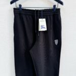 Pantaloni jogger neri in morbido tessuto con logo e etichetta, ideali per sport e relax.