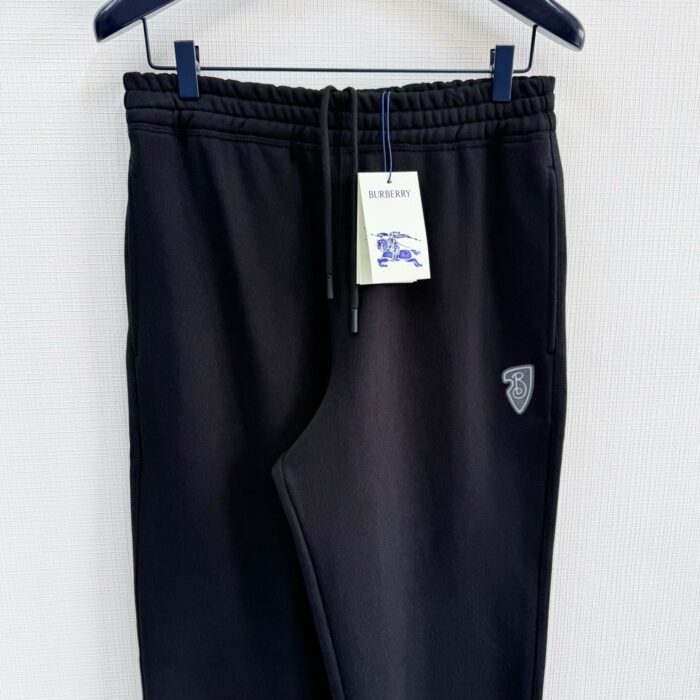 Pantaloni jogger neri in morbido tessuto con logo e etichetta, ideali per sport e relax.