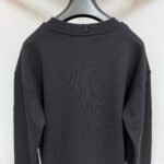 Felpa nera semplice con spalle cadenti, ideale per look casual e minimalisti.
