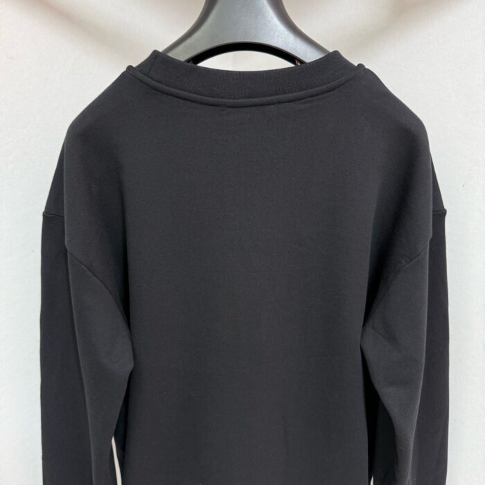 Felpa nera semplice con spalle cadenti, ideale per look casual e minimalisti.