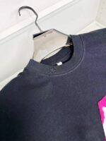 Felpa nera con grafica rosa vivace in stile streetwear, comoda e alla moda.