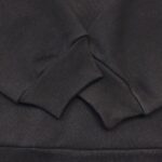 Maglia felpa nera con polsini a costina e cuciture pulite, ideale per casual e comfort.
