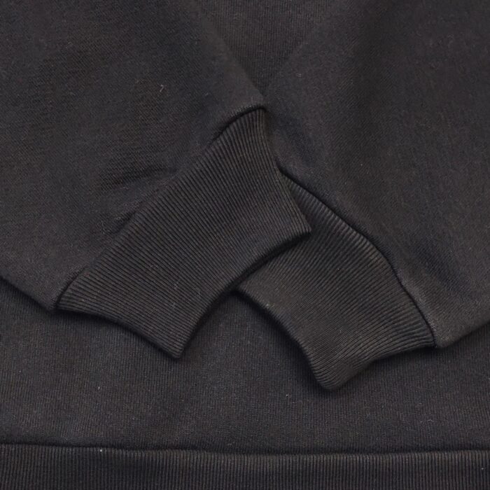 Maglia felpa nera con polsini a costina e cuciture pulite, ideale per casual e comfort.