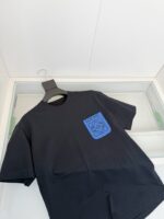 T-shirt nera con grafica astratta blu, stile streetwear casual e moderno.