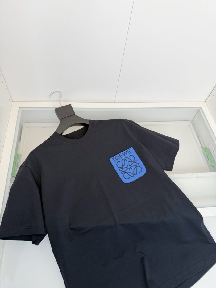 T-shirt nera con grafica astratta blu, stile streetwear casual e moderno.