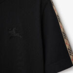 T-shirt nera con dettagli Burberry, logo tono su tono e maniche con motivo a quadri.