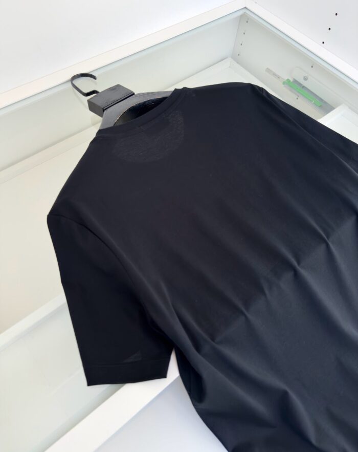 T-shirt nera minimalista su sfondo bianco, semplice, eleganti e versatile, perfetta per ogni occasione.