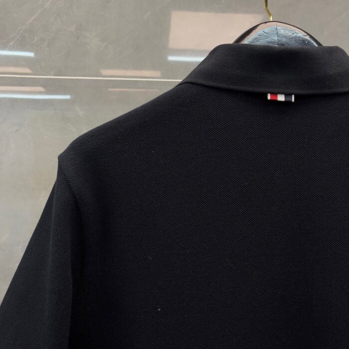 Camicia nera elegante con colletto strutturato e logo colorato sul retro.