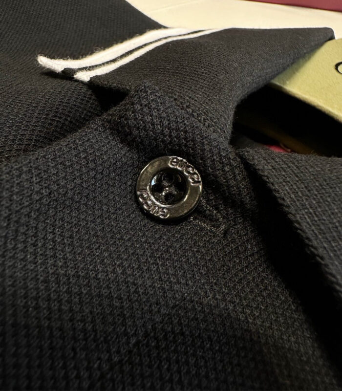 Blazer nero con bottone lucido, dettaglio a fascia bianca e tessuto elegante.
