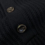 Maglione nero in maglia con bottoni in metallo e texture calda e elegante.