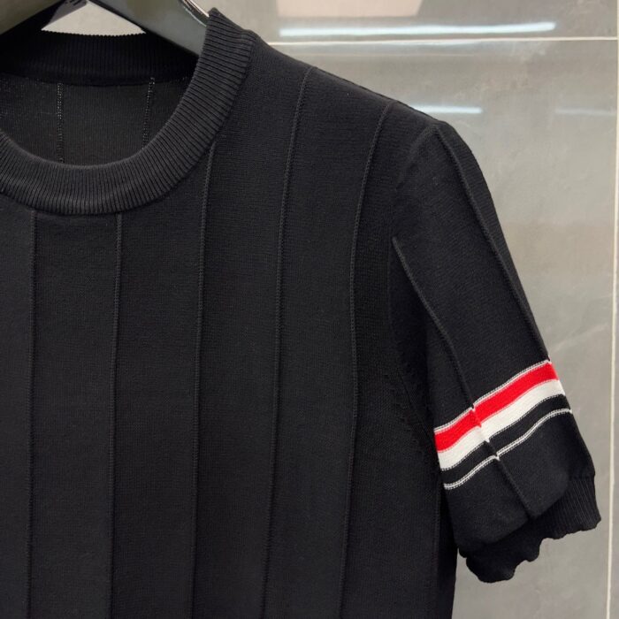 Camicia nera girocollo con dettagli sportivi a righe sui manici, versatile e elegante.