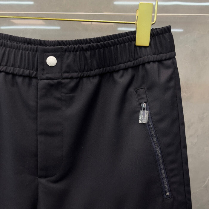 Pantaloni neri elasticizzati con tasche zip, cintura a vita alta e look moderno e confortevole.