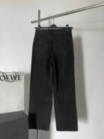 Pantaloni neri minimalisti in denim con borsa LOEWE su scaffale di lusso.