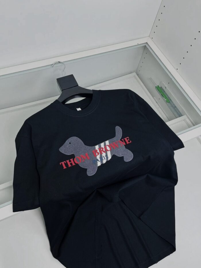 Maglietta nera con grafica di cane e logo collaborativo in stile streetwear.
