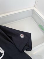 Maglietta nera con logo sulla manica in vetrina minimalista e elegante.