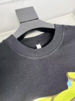 Maglietta nera con stampa colorata e colletto a costine, perfetta per look casual e streetwear.