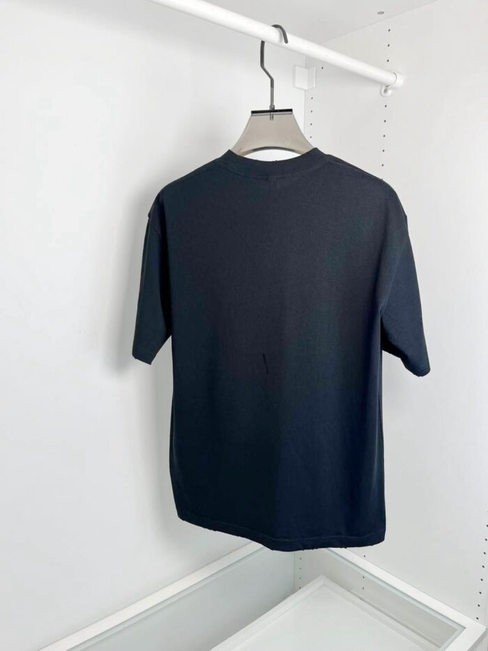 Maglietta nera minimalista in cotone con colletto rotondo e maniche corte, elegante e versatile.