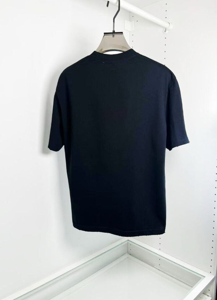 Maglietta nera basic da uomo, comoda e versatile, su attaccapanni bianco per look casual.