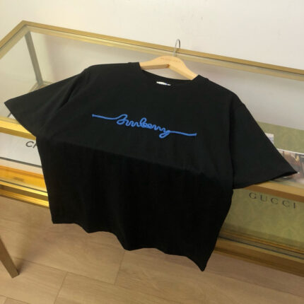 T-shirt nero oversize con logo blu, stile casual chic, ideale per look moderni e di tendenza.
