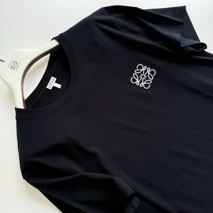 Maglietta nera minimalista con logo bianco, design elegante e stile casual moderno.