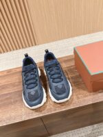 Sneakers sportive moderne navy con scatola arancione, stile casual e performance su superficie in legno.