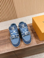 Sneakers Louis Vuitton in denim con scatola arancione su sfondo in legno elegante.
