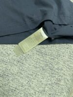 Etichetta di cura su tessuto scuro, istruzioni per lavaggio e manutenzione del vestito elegante.