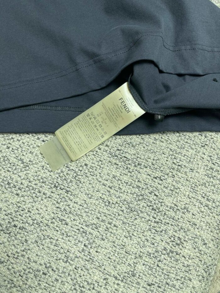 Etichetta di cura su tessuto scuro, istruzioni per lavaggio e manutenzione del vestito elegante.