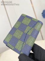Portafoglio slim checkered blu e verde, compatto e stile moderno, in mano con dettaglio curato.