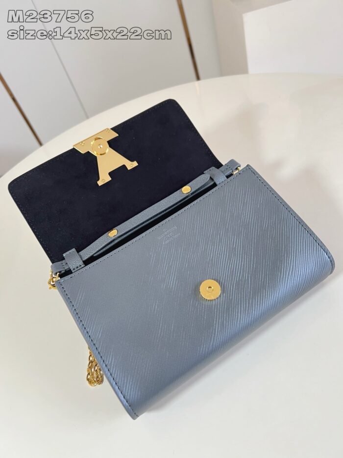 Borsa blu elegante con dettagli oro e interno in velluto, stile sofisticato e di tendenza.
