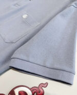 Maglietta polo blu chiaro con tasca e logo, stile casual elegante e confortevole.