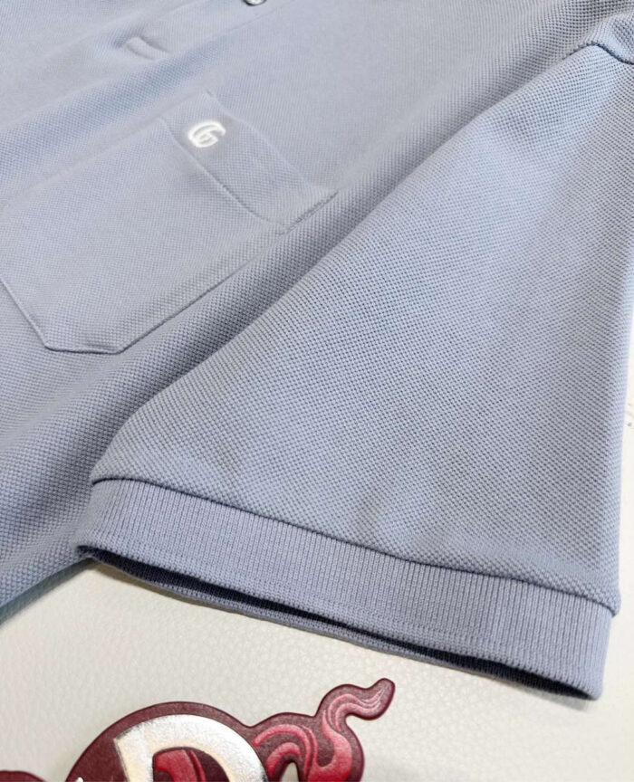 Maglietta polo blu chiaro con tasca e logo, stile casual elegante e confortevole.