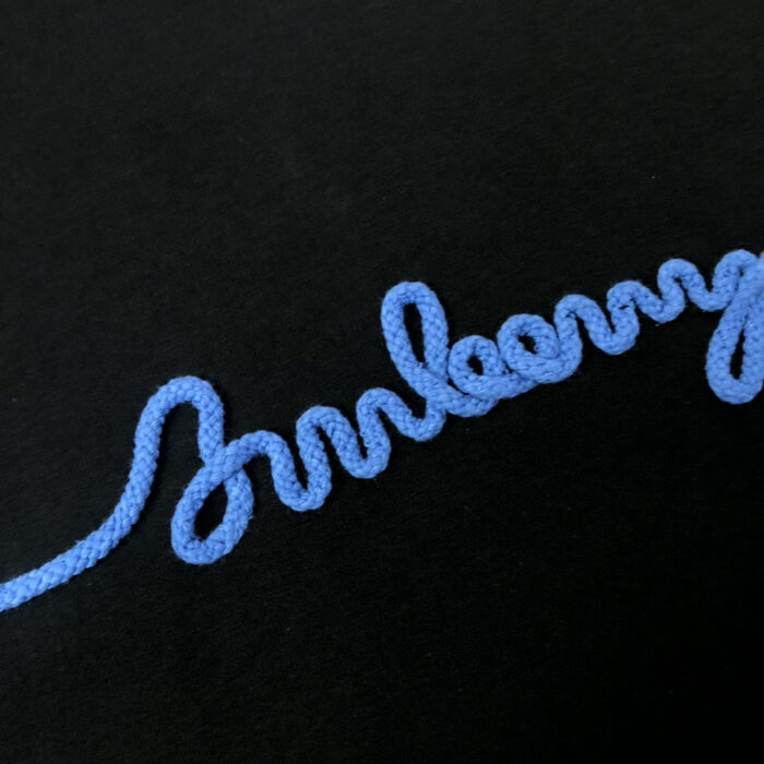 Parola Blueberry in corda blu su sfondo nero, arte fatta a mano e creativa.