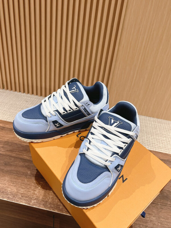 Sneakers blu navy e azzurro su scatola arancione, stile sportivo e moderno, ideali per il daily wear.