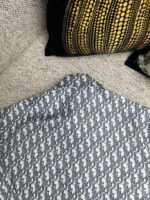Tessuto geometrico blu e bianco con cuscini decorativi in ambiente accogliente.