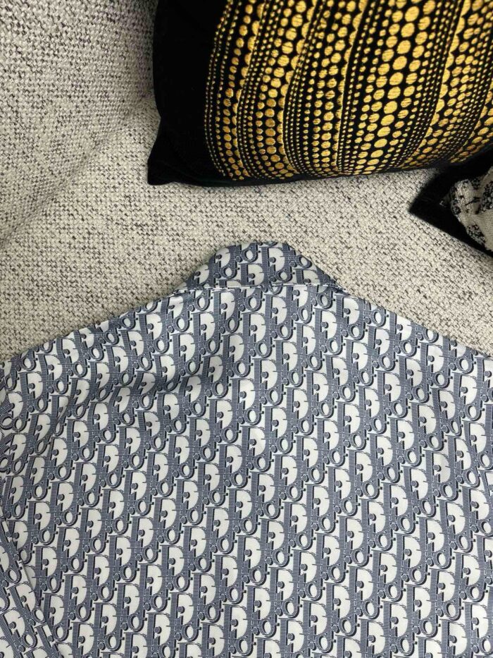 Tessuto geometrico blu e bianco con cuscini decorativi in ambiente accogliente.