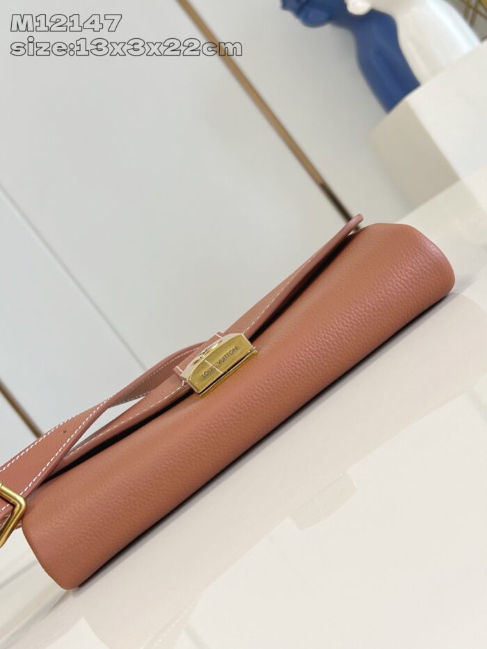 Borsa beige in pelle con chiusura oro, elegante e versatile, su superficie riflettente.