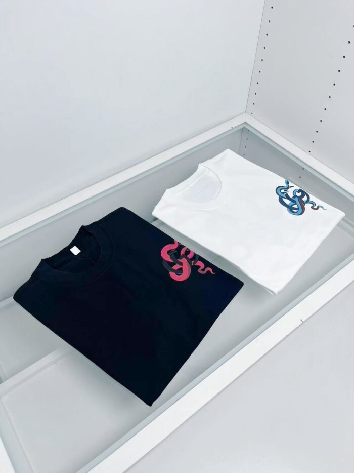 T-shirt nero e bianco con design di serpente colorato, stile moderno e contrasto vivace.