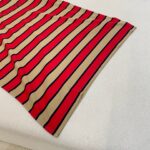 Fazzoletto a righe rosse, beige e nere, decorativo e elegante.