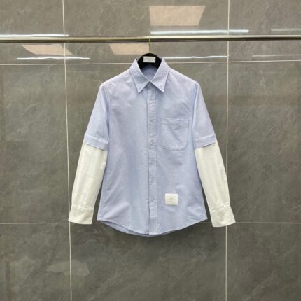 Camicia moderna con maniche bianche a contrasto e dettagli innovativi, stile casual e sofisticato.