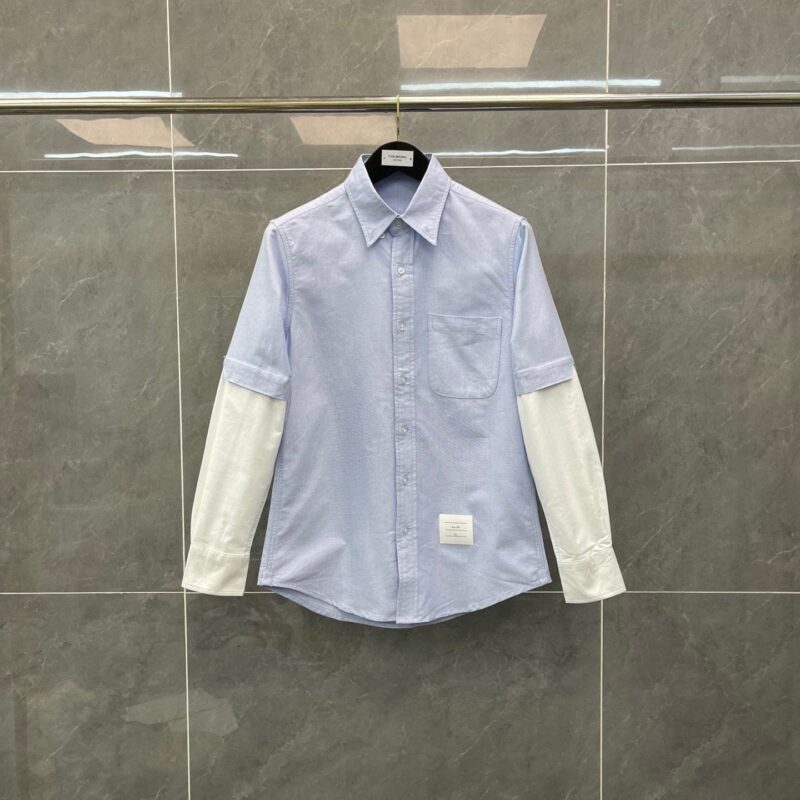 Camicia moderna con maniche bianche a contrasto e dettagli innovativi, stile casual e sofisticato.
