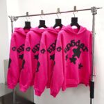 Felpe rosa vivace con grafica stelle e testo nero, stile streetwear moderno e trendy.