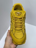 Scarpa sneakers gialla moderna sportiva, design robust, suola chunky, stile versatile e dinamico.