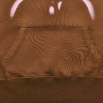 Felpa marrone con tasca a sacco e design grafico elegante, ideale per look casual e confortevoli.