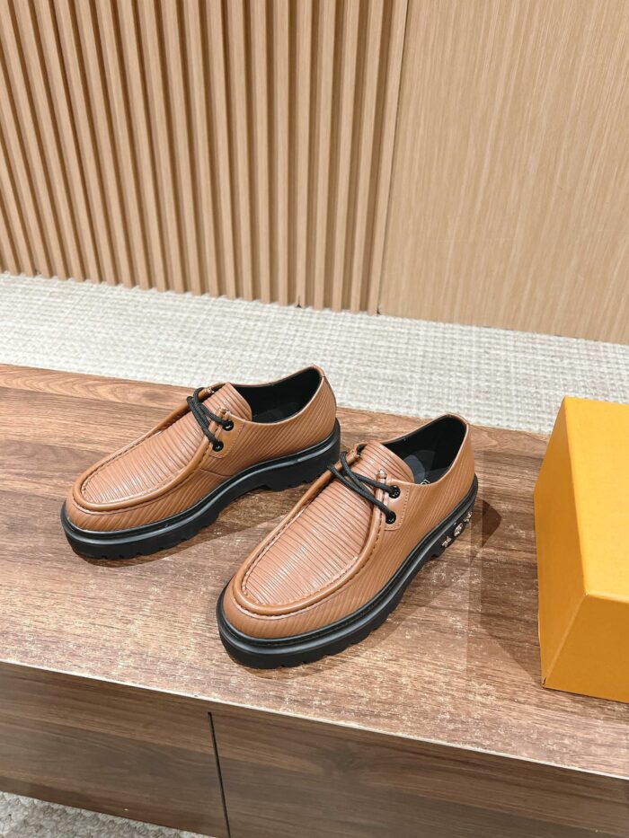 Scarpe in pelle marrone eleganti slip-on su superficie in legno, stile raffinato e moderno.