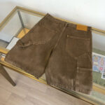 Shorts di jeans marroni con tasche decorabili e dettagli hardware eleganti, stile casual e vintage.
