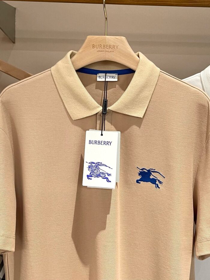 Maglietta polo beige Burberry con logo ricamato blu, stile elegante e di lusso.