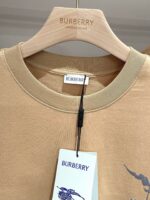 T-shirt beige Burberry con grafica moderna e dettagli eleganti su gruccia di qualità.