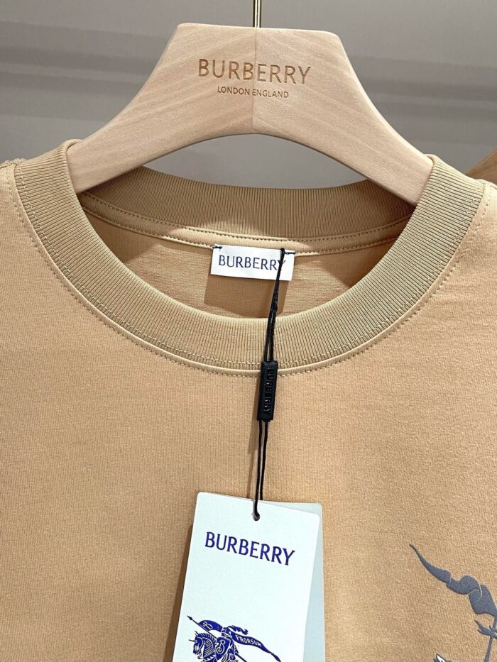 T-shirt beige Burberry con grafica moderna e dettagli eleganti su gruccia di qualità.